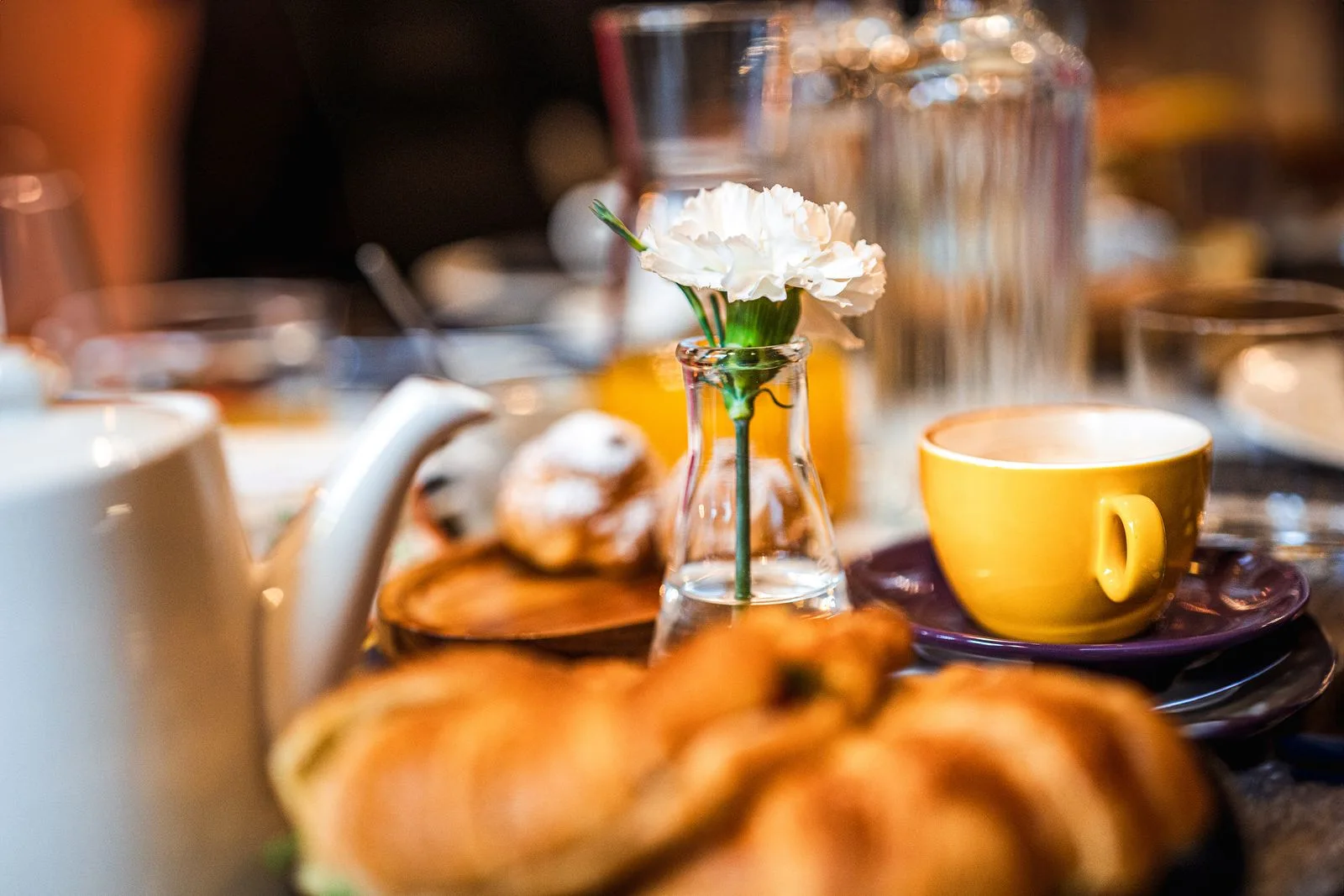 Coffee, a croissant and flowers on a small table