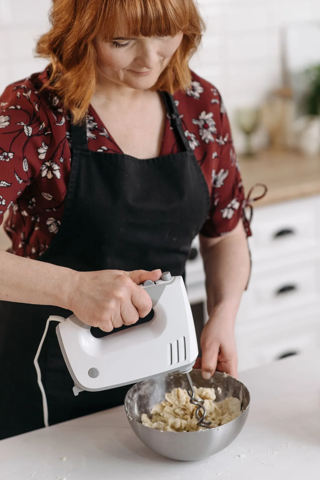 A home baker using an electric hand mixer