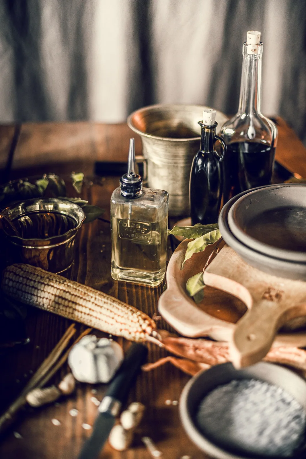 Bottles, spices and kitchen utensils on a wooden table